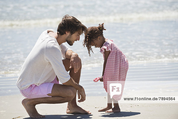 Man playing with his daughter the beach