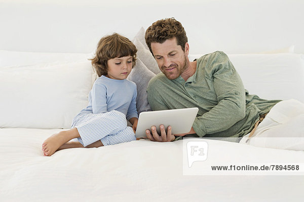 Mann zeigt seinem Sohn ein digitales Tablett