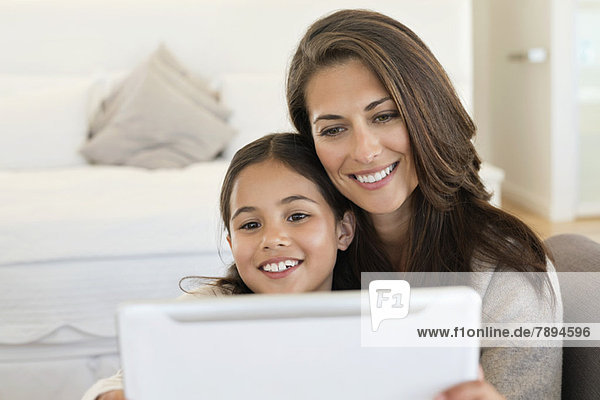 Woman and her daughter looking at a digital tablet