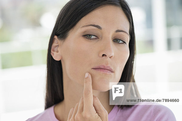 Woman checking wrinkles on her face