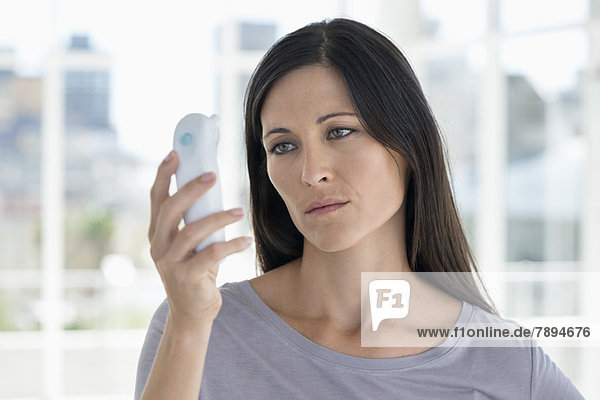 Woman reading a digital thermometer