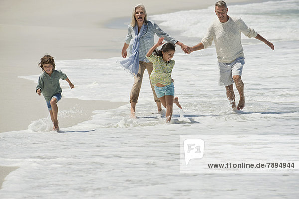 Kinder beim Spielen mit ihren Großeltern am Strand