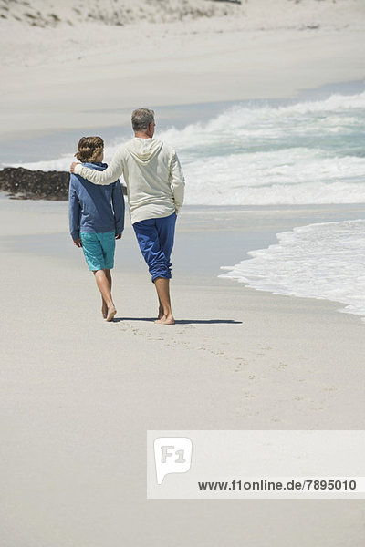 Man walking with his grandson on the beach