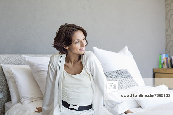 Woman sitting on the bed and smiling