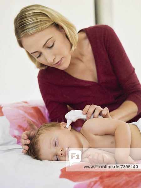 Woman taking her baby's temperature