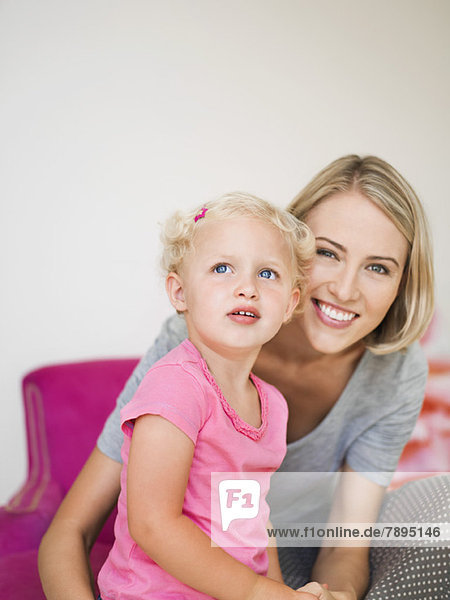 Lächelnde Frau sitzend mit ihrer Tochter