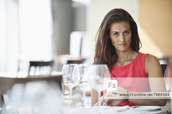 Woman sitting in a restaurant and looking at wristwatch