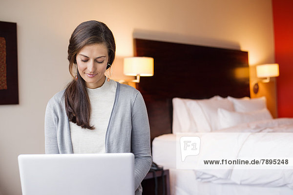Woman using a laptop in a hotel room