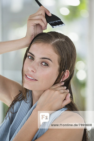 Porträt einer Frau beim Haare färben