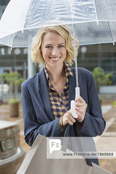 Porträt einer lächelnden Frau mit Regenschirm