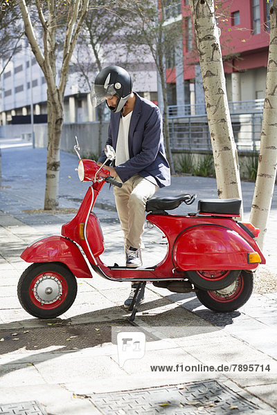 Man standing with a scooter