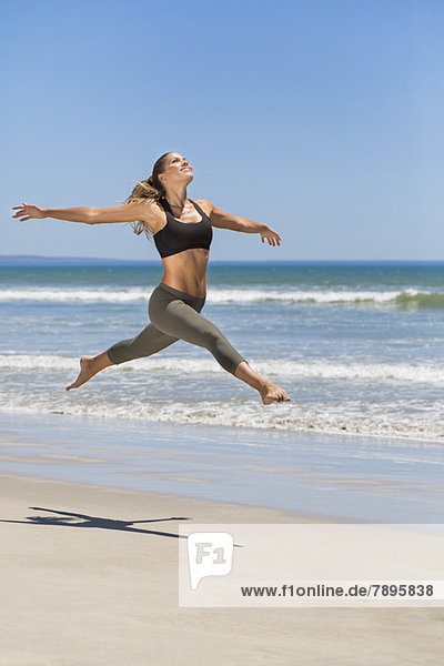Frau beim Springen am Strand