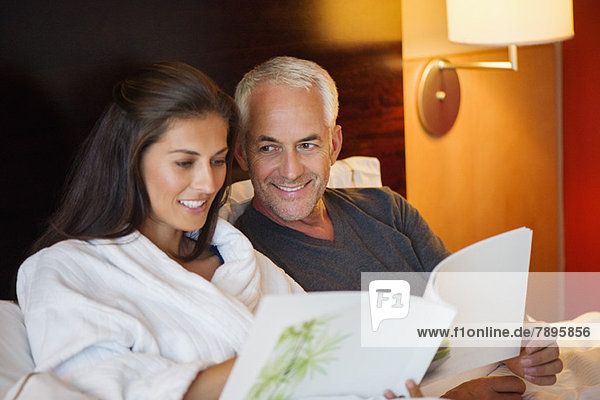 Couple reading a book in a hotel room