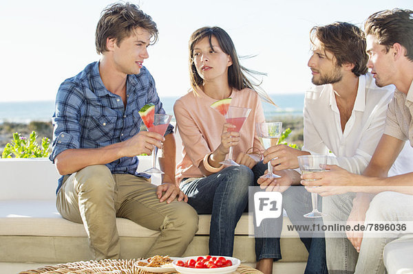 Group of friends enjoying drinks outdoors on vacation