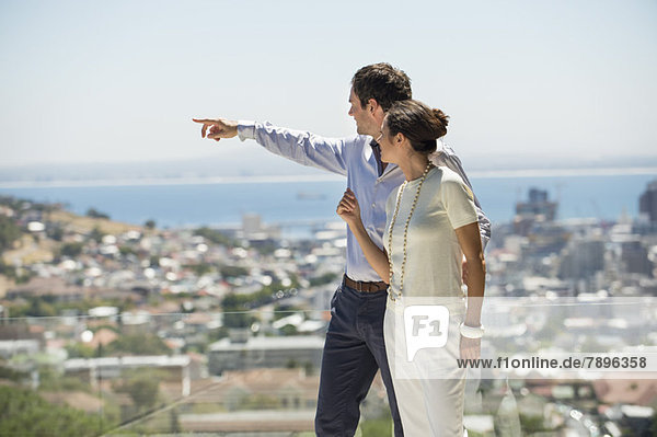 Couple looking at city view from a terrace