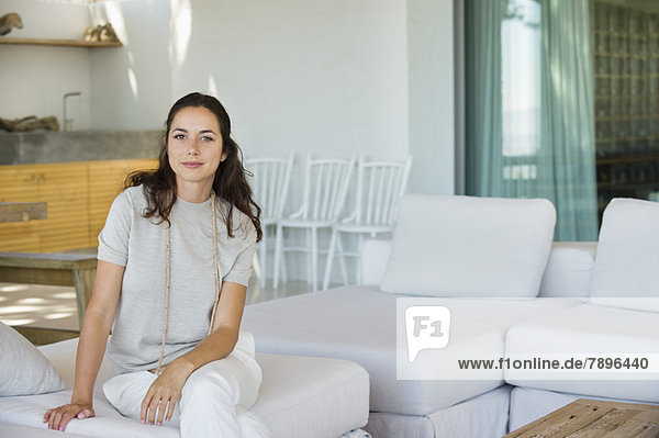 Porträt einer schönen Frau auf einer Couch sitzend