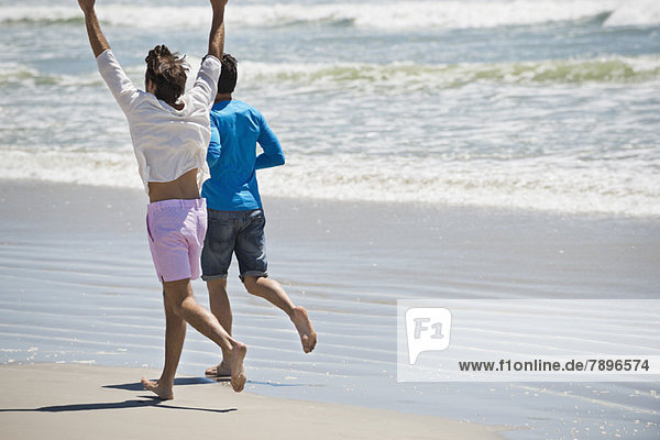 Two men running on the beach