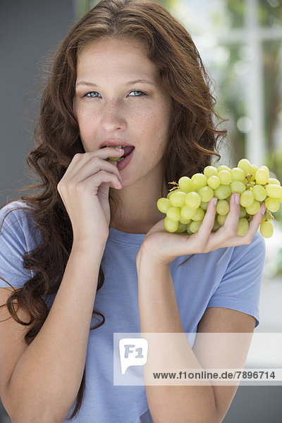 Porträt einer Frau beim Traubenessen