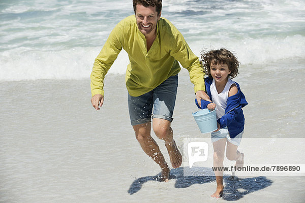 Mann spielt mit seinem Sohn am Strand