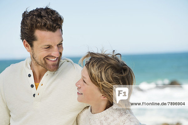 Man with his son smiling on the beach