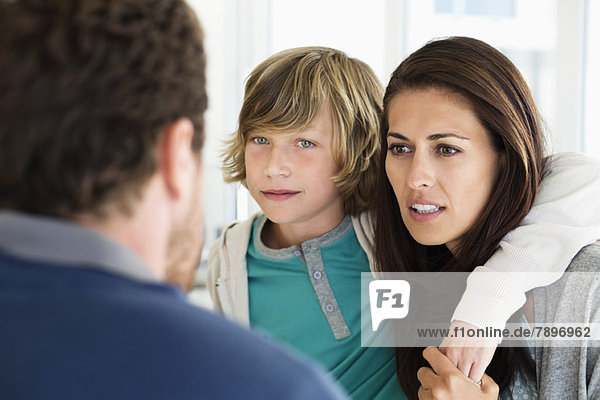 Junge mit seinen Eltern diskutiert zu Hause