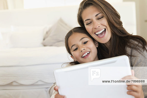 Frau und ihre Tochter betrachten ein digitales Tablett
