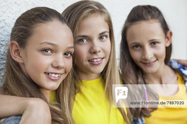 Drei Mädchen lächeln zusammen