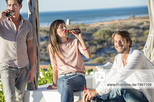 Group of friends enjoying beer outdoors on vacation