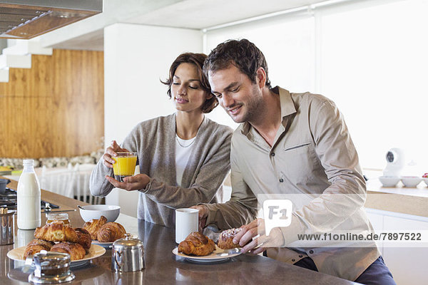 Couple having breakfast at a kitchen counter