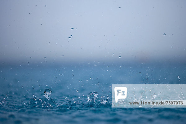 Regentropfen fallen ins Meer