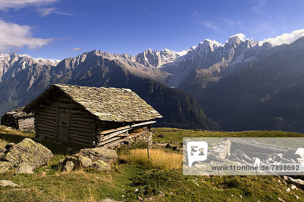 Old wooden hut with slated roof  peaks of the Bregaglia Range at back
