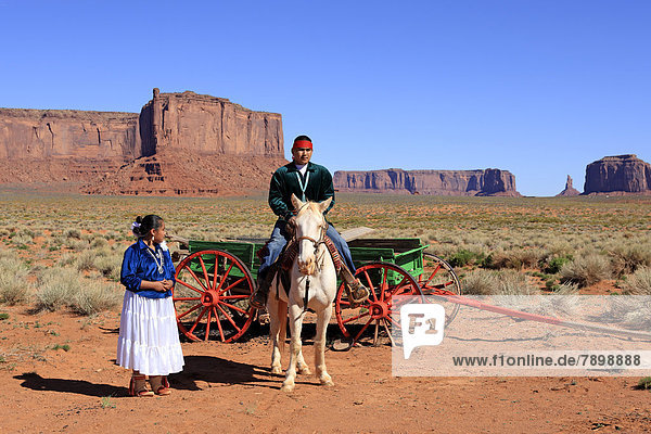 Navajo Indians  man and woman with a horse in front of a carriage