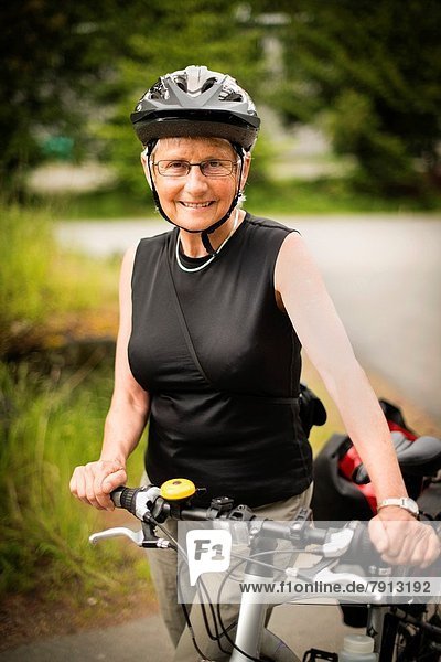 A woman  66  with her bicycle on Saturna Island  Gulf Islands  British Columbia  Canada