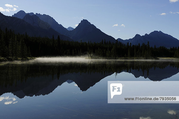 Foothills of the Rocky Mountains reflected in a lake  Kananaski Country  Alberta  Canada