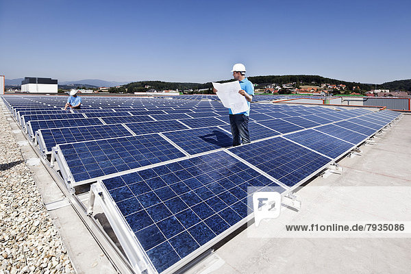 Zwei Techniker inspizieren Solaranlage