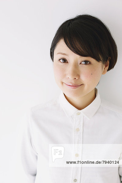 Young woman in a white shirt smiling at camera