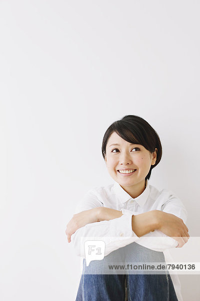 Young woman in a white shirt sitting on the floor