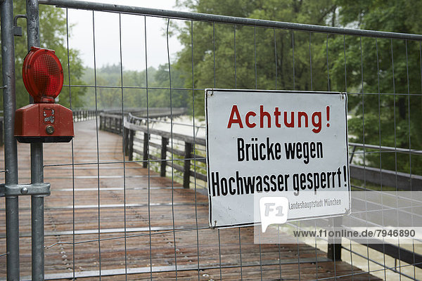'Absperrung mit Warnschild ''Achtung! Holzbrücke wegen Hochwassers gesperrt'''