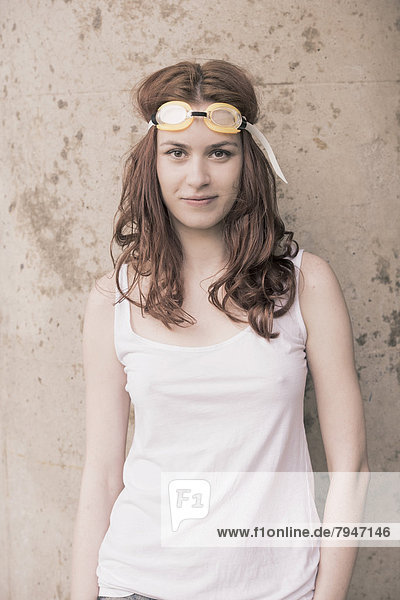 Portrait of a young woman with swimming goggles on her head