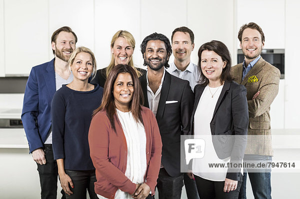 Portrait of multi-ethnic business people standing together in office