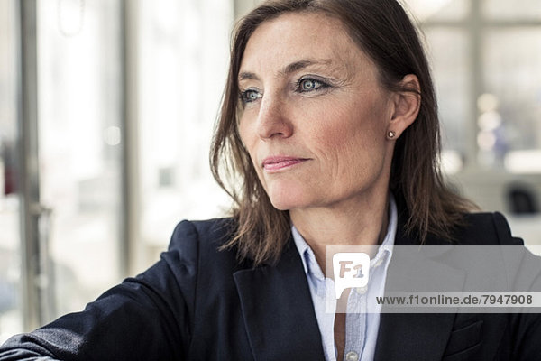 Thoughtful mature businesswoman looking away in office