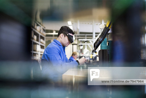 Seitenansicht des in der Industrie tätigen Technikers mit Schutzbrille