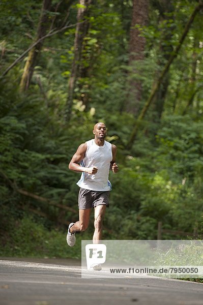 Young african american man running in city park