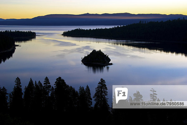 A magnificent sunrise over Emerald Bay with clouds reflecting in the calm water in Lake Tahoe  CA.