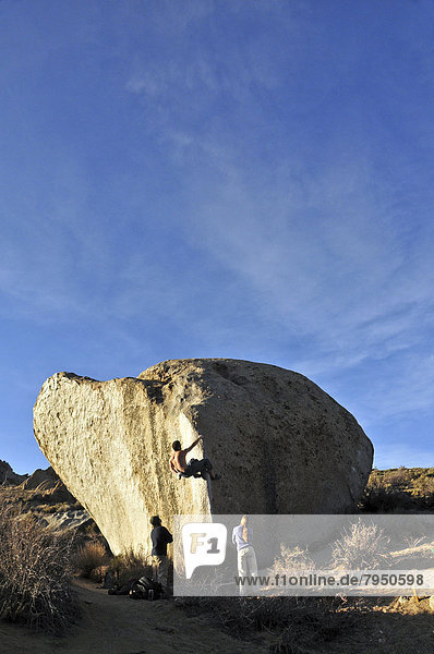 A rock climber boulders on an arete at the Buttermilks near Bishop  CA.