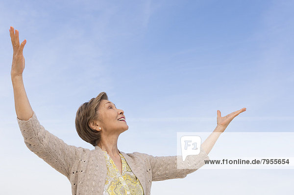 Senior woman looking up at blue sky
