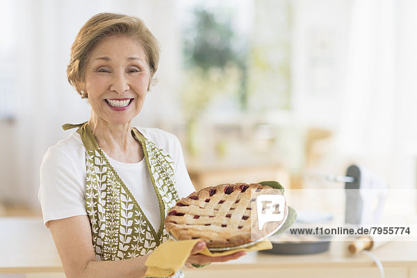Senior woman holding freshly baked cake