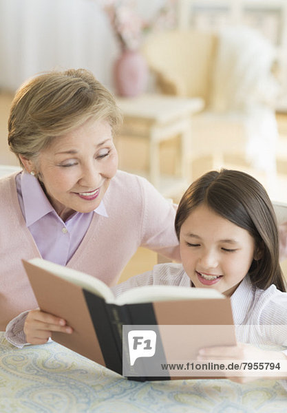 Granddaughter (8-9) and grandmother reading book