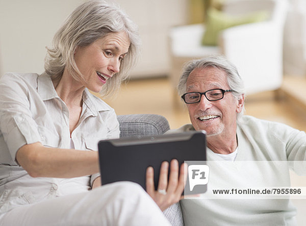 Senior couple using digital tablet at home