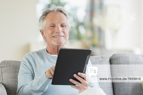 sitzend  Senior  Senioren  Mann  Couch  Tablet PC